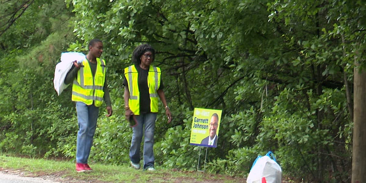 Volunteers with trash bags cleaning up litter in Augusta, Georgia neighborhood streets