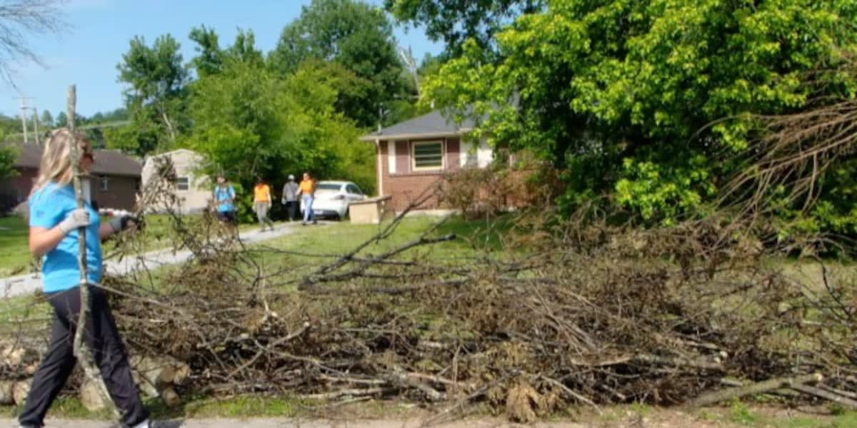 Tennessee Titans volunteers hauling tree branches and storm debris from residential yards in Nashville