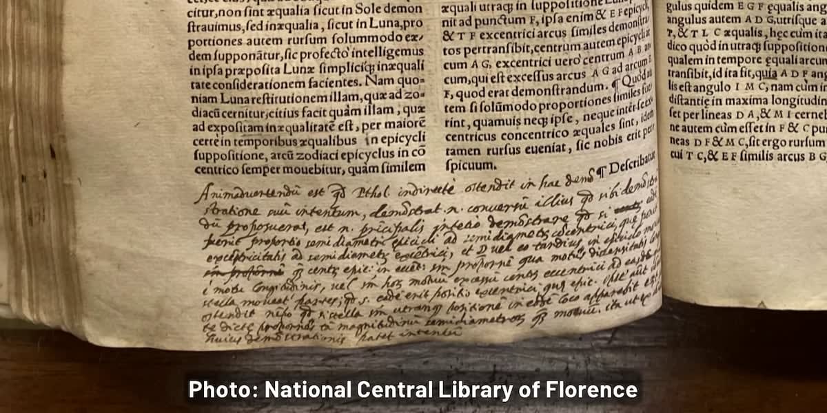 Ancient printed book open to pages with handwritten notes in margins from Galileo Galilei