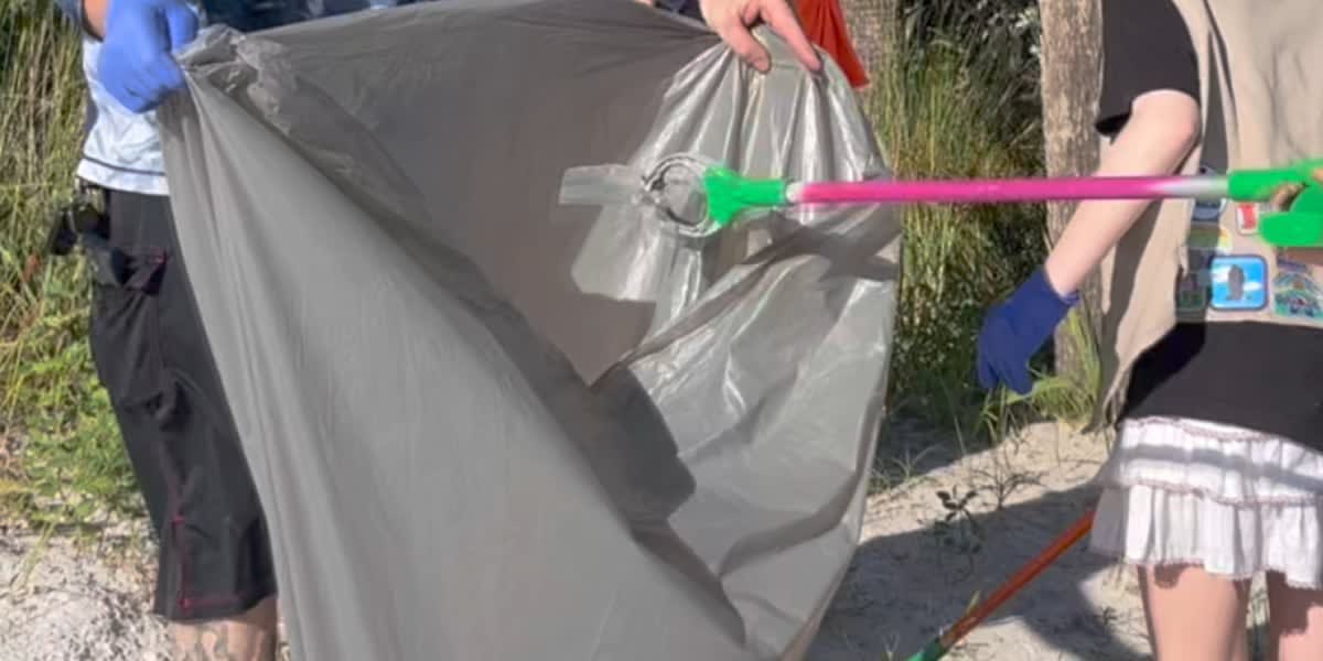 Young Girl Scouts wearing gloves use trash grabbers to pick up litter on sandy Siesta Key Beach