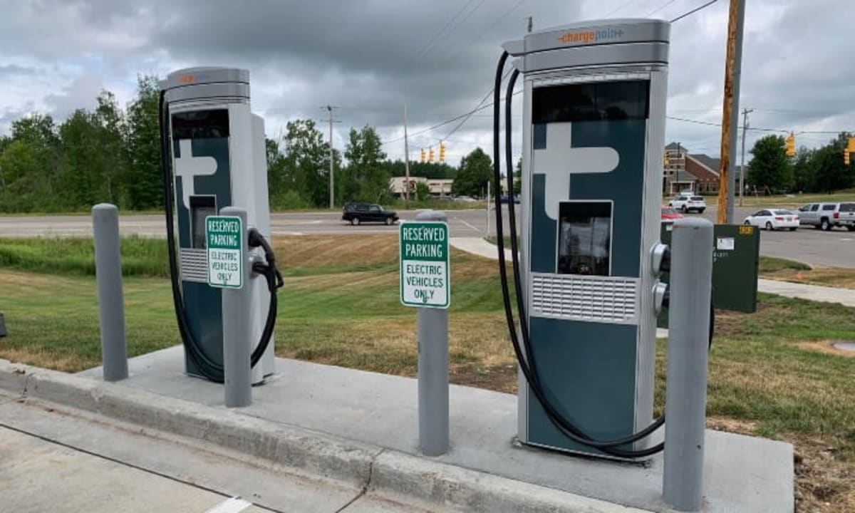 Electric vehicle charging station along Michigan highway with cars plugged in