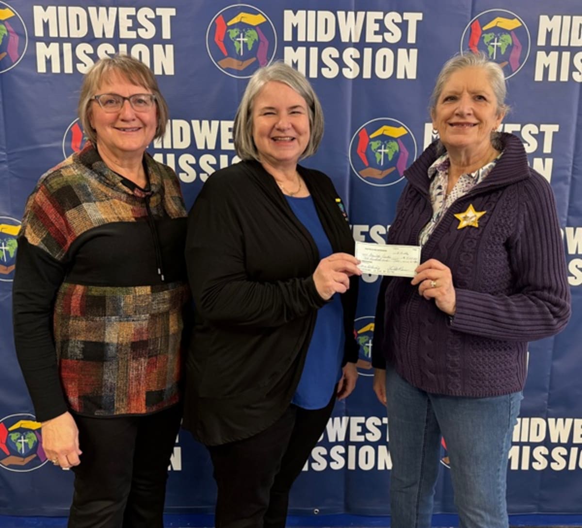 Three women standing together at scholarship award presentation ceremony in Iowa