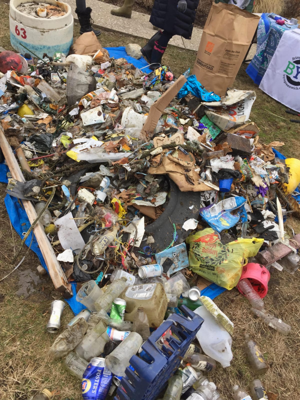 Volunteers collecting debris along sandy beach shoreline during community cleanup event