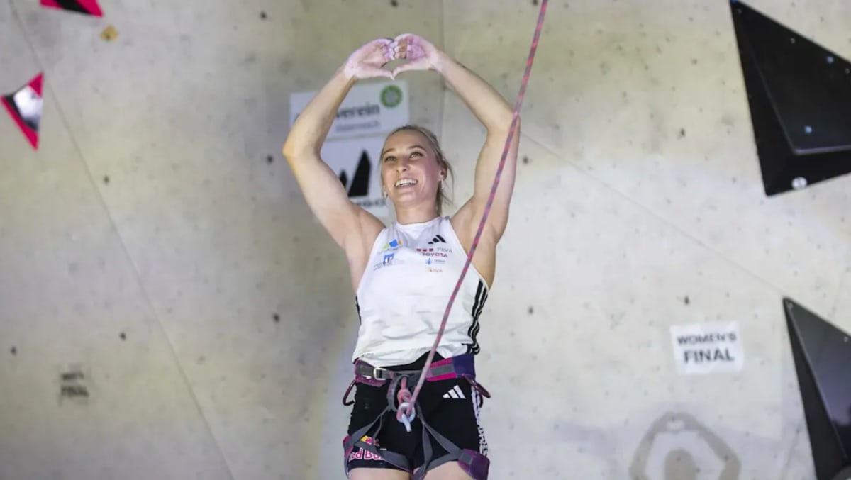 Janja Garnbret celebrating on podium after winning her 50th World Cup gold medal in climbing