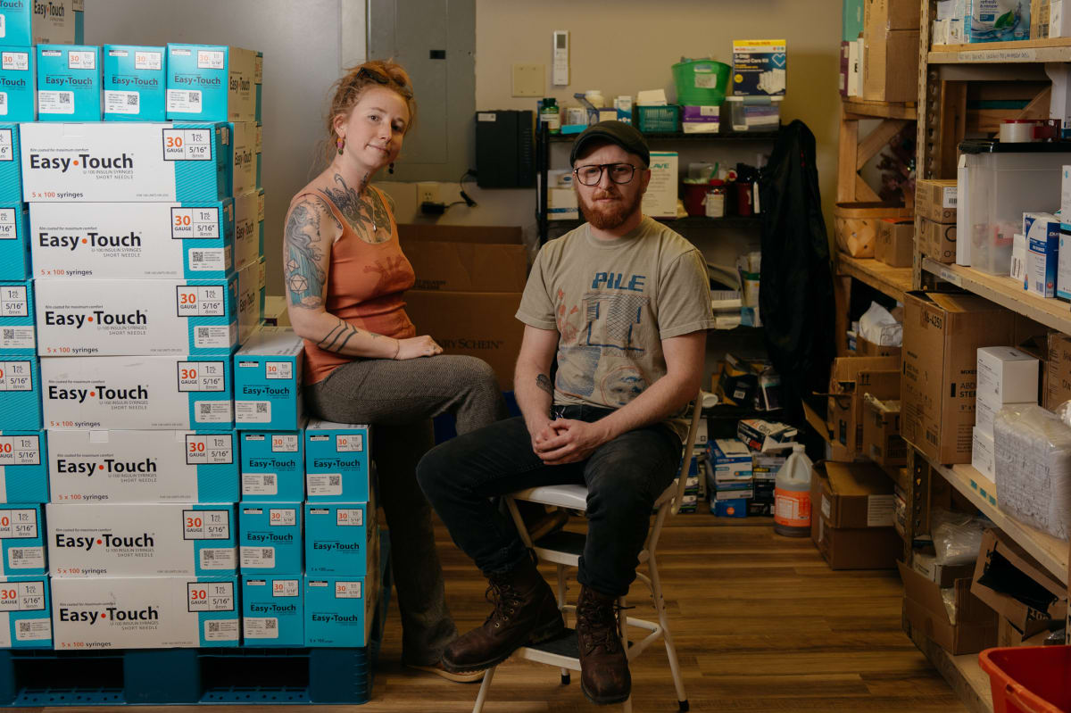 Kimberly Treadaway and Oscar Smith sit beside harm reduction supplies at Holler office