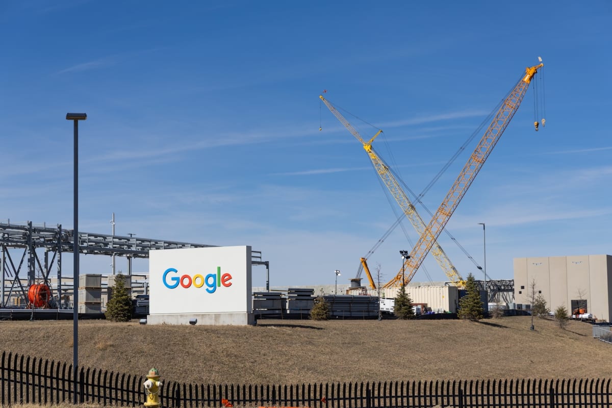 Modern data center facility with cooling towers in rural Nebraska agricultural landscape
