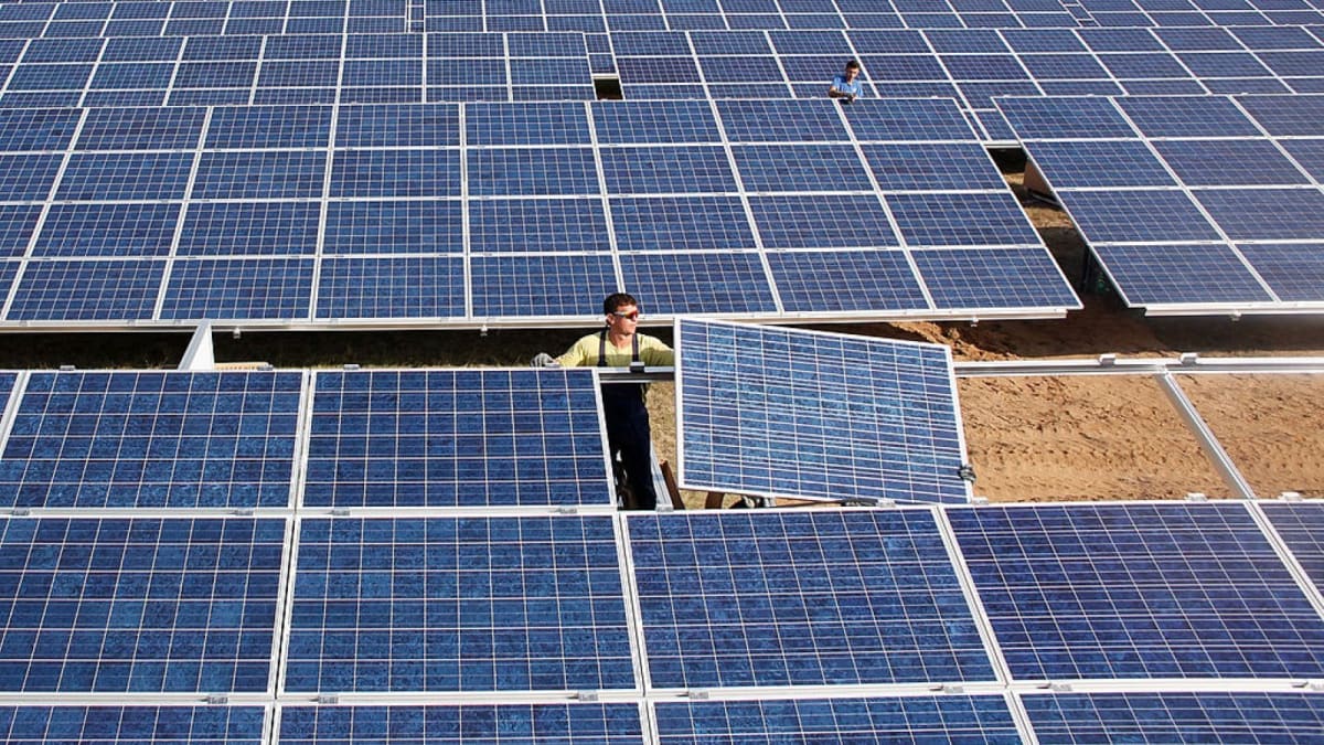 Solar panels gleaming under bright European sun with clear blue skies overhead