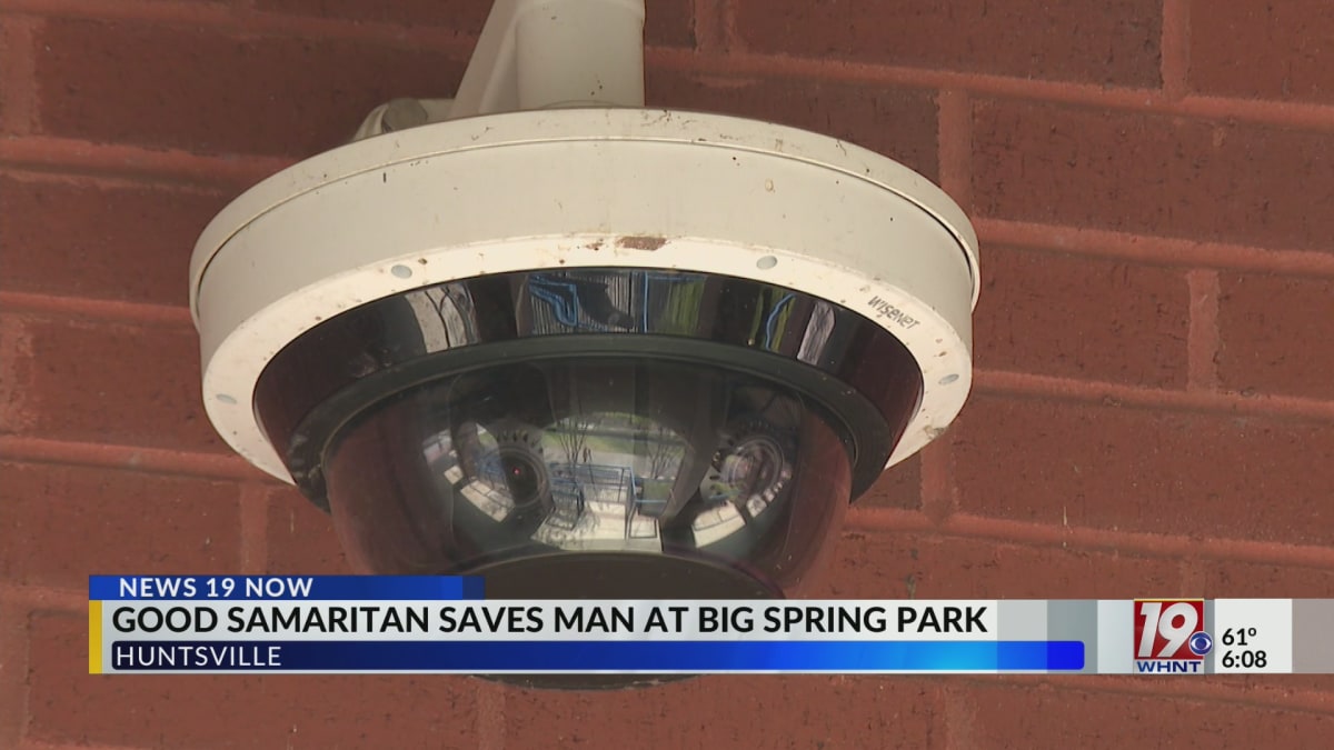 ** Utility worker in safety vest standing near Big Spring Park water feature in Alabama
