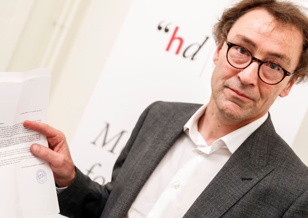 ** Peace mediator David Harland holding ETA disbandment document in Geneva office