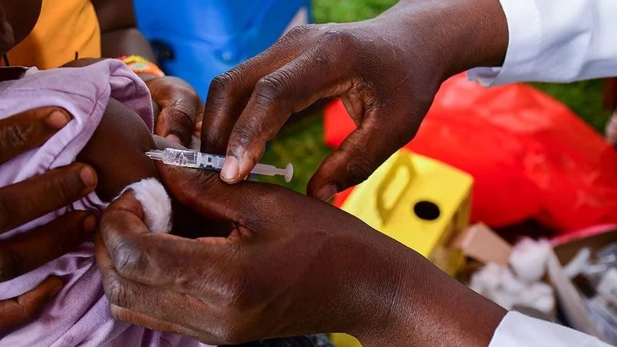 Healthcare worker administering HPV vaccine to adolescent girl at vaccination clinic in Kenya
