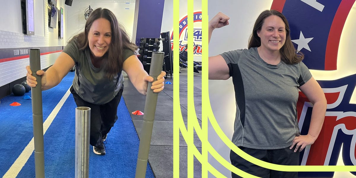Smiling woman in her forties holding weights during group fitness class in gym