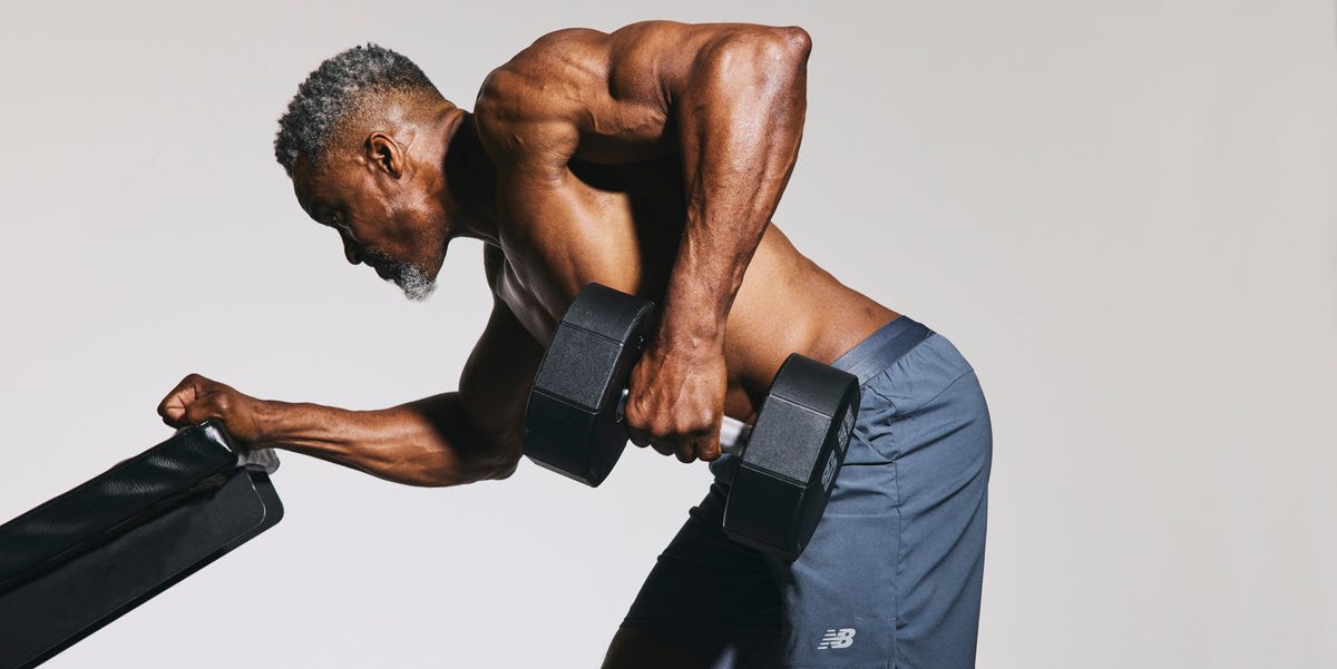 ** Fit man over 50 lifting dumbbells in gym showing strength and determination