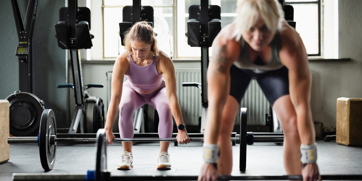Woman over 50 lifting weights confidently in gym showing proper strength training form