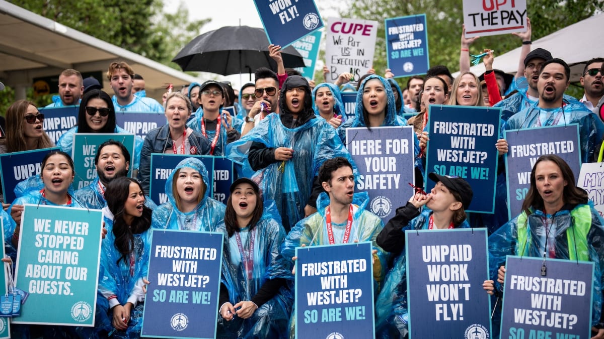 WestJet airplane on tarmac with flight attendants preparing for boarding operations