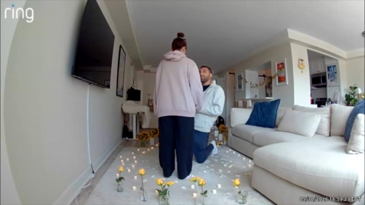 ** Happy engaged couple laughing together after unconventional marriage proposal at home
