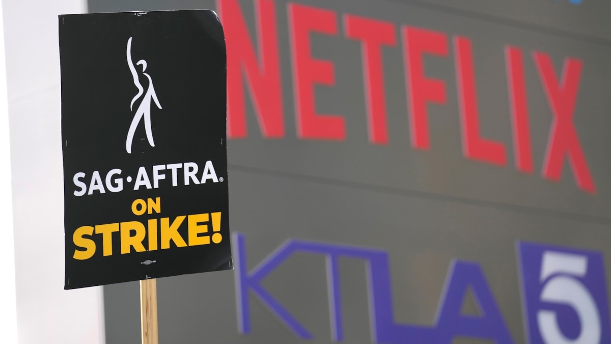 Hollywood film studio lot with writer's script and coffee cup on desk in foreground