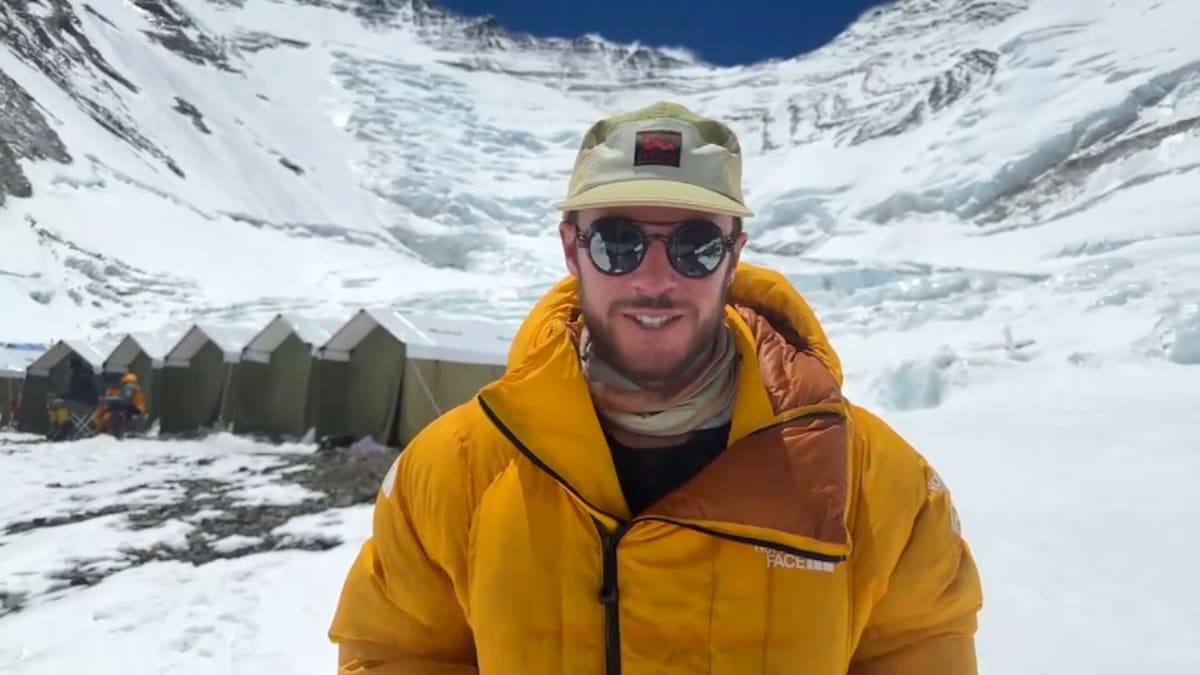 Climber Oliver Foran standing near snowy Mount Everest base camp after surviving avalanche
