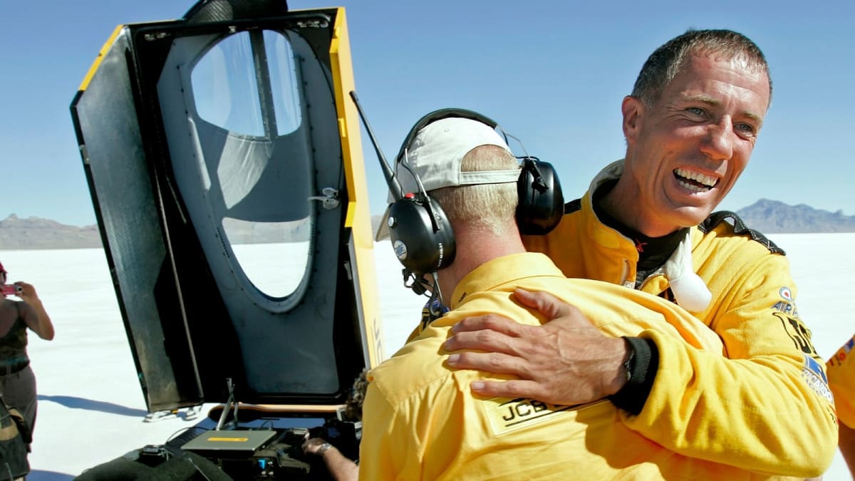 Bright yellow hydrogen-powered JCB Hydromax speed car on white Bonneville Salt Flats in Utah
