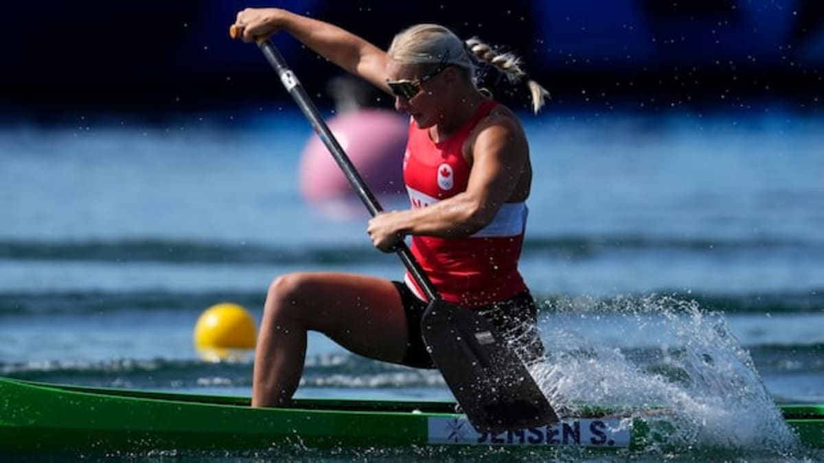 Canadian canoeist Sophia Jensen competing in sprint canoe race wearing red and white