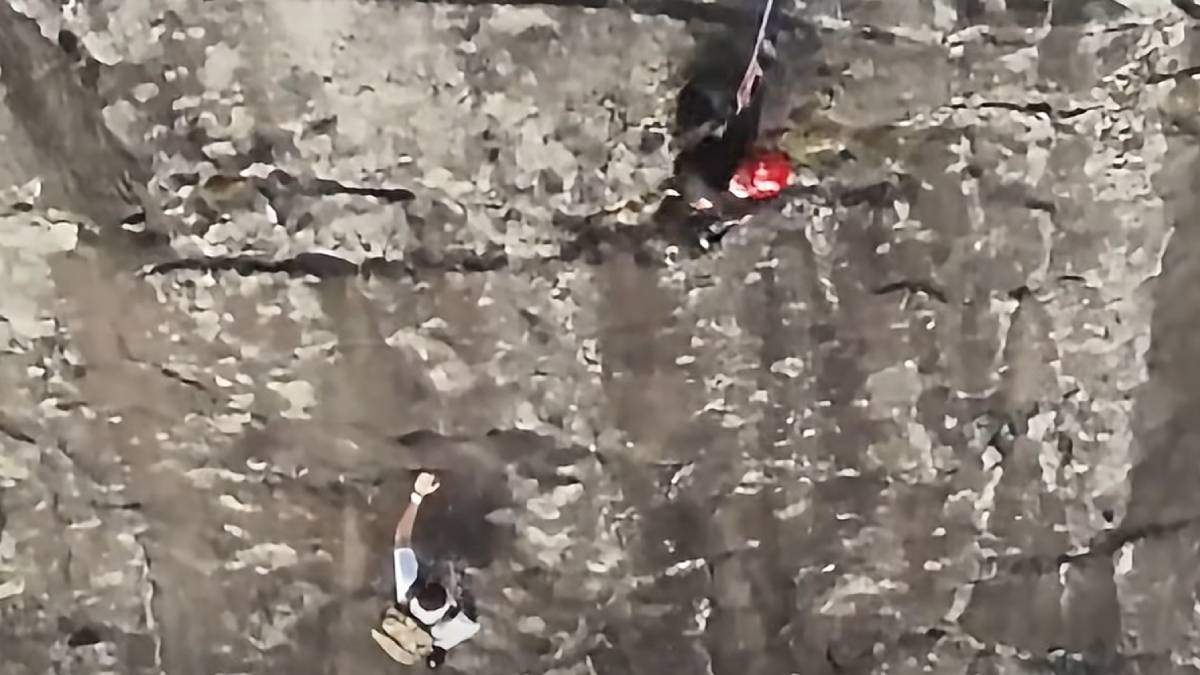 Firefighter rappelling down rocky cliff face during dramatic mountain rescue operation in Georgia