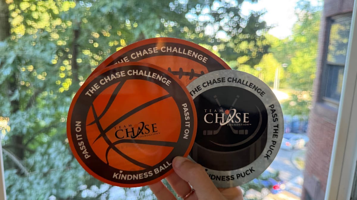 Brooke DeBarros holding circular Chase Kindness Ball disks designed like sports equipment