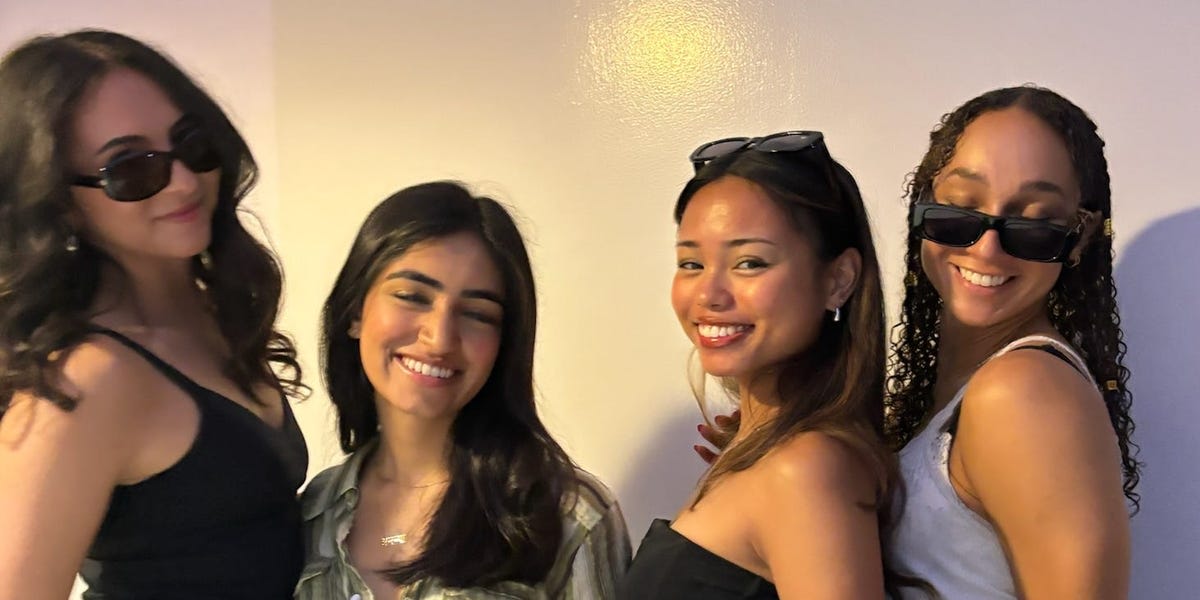 ** Four young women smiling together at a house party in San Francisco