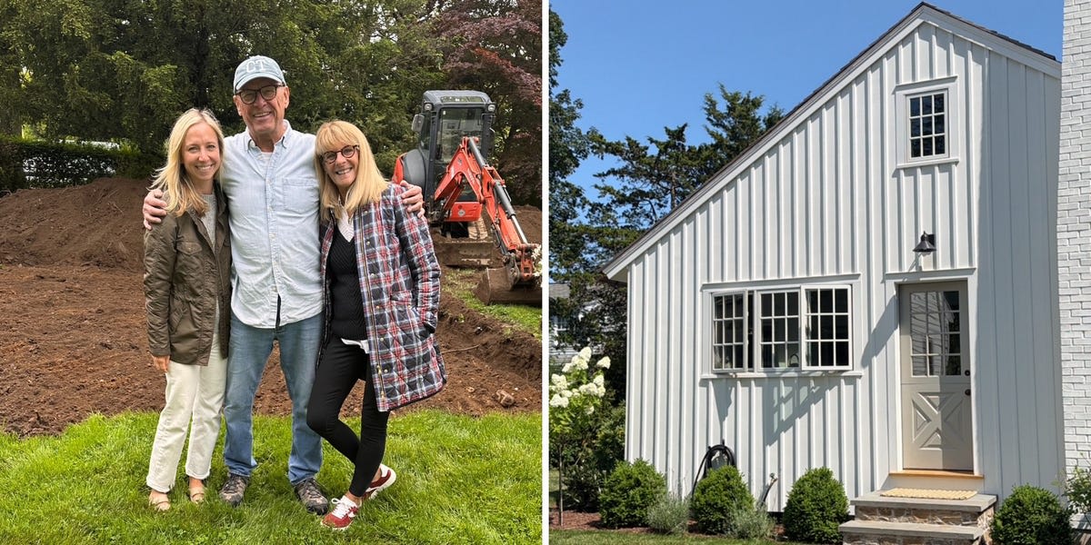 Elderly couple smiling in white doorway of new backyard cottage with potted fern