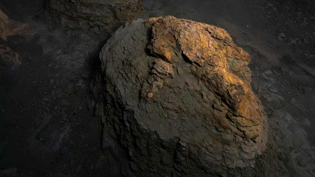 Three illuminated dinosaur footprints visible in rocky North Dakota badlands terrain under starry night sky