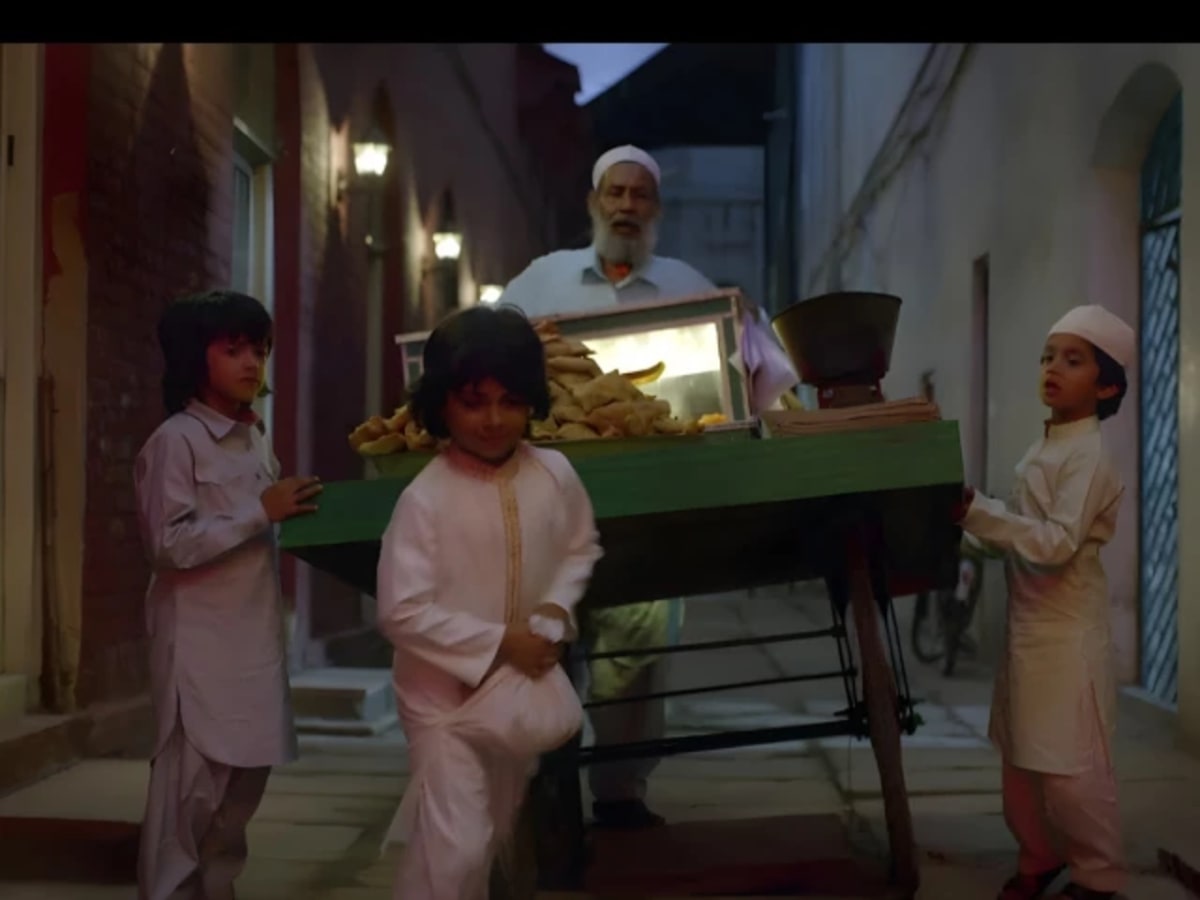Young Pakistani boy smiling while sharing food during Ramadan iftar celebration with family