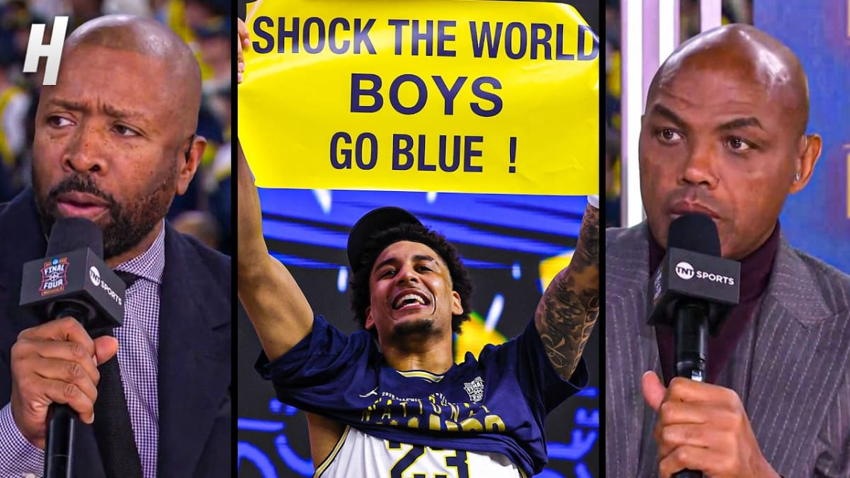 Michigan Wolverines basketball team celebrating with NCAA championship trophy in Indianapolis arena