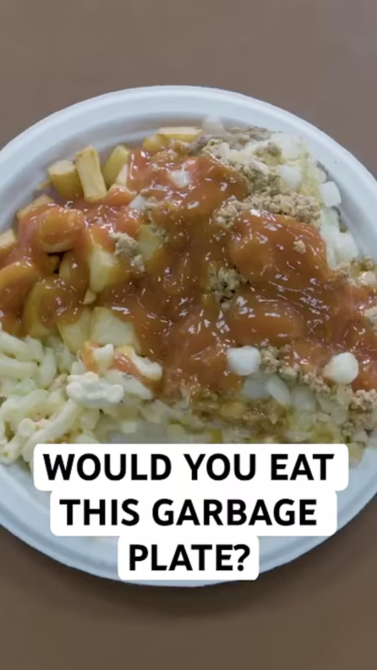 Overflowing garbage plate with fries, meat, and colorful toppings at Nick Tahou Hots diner