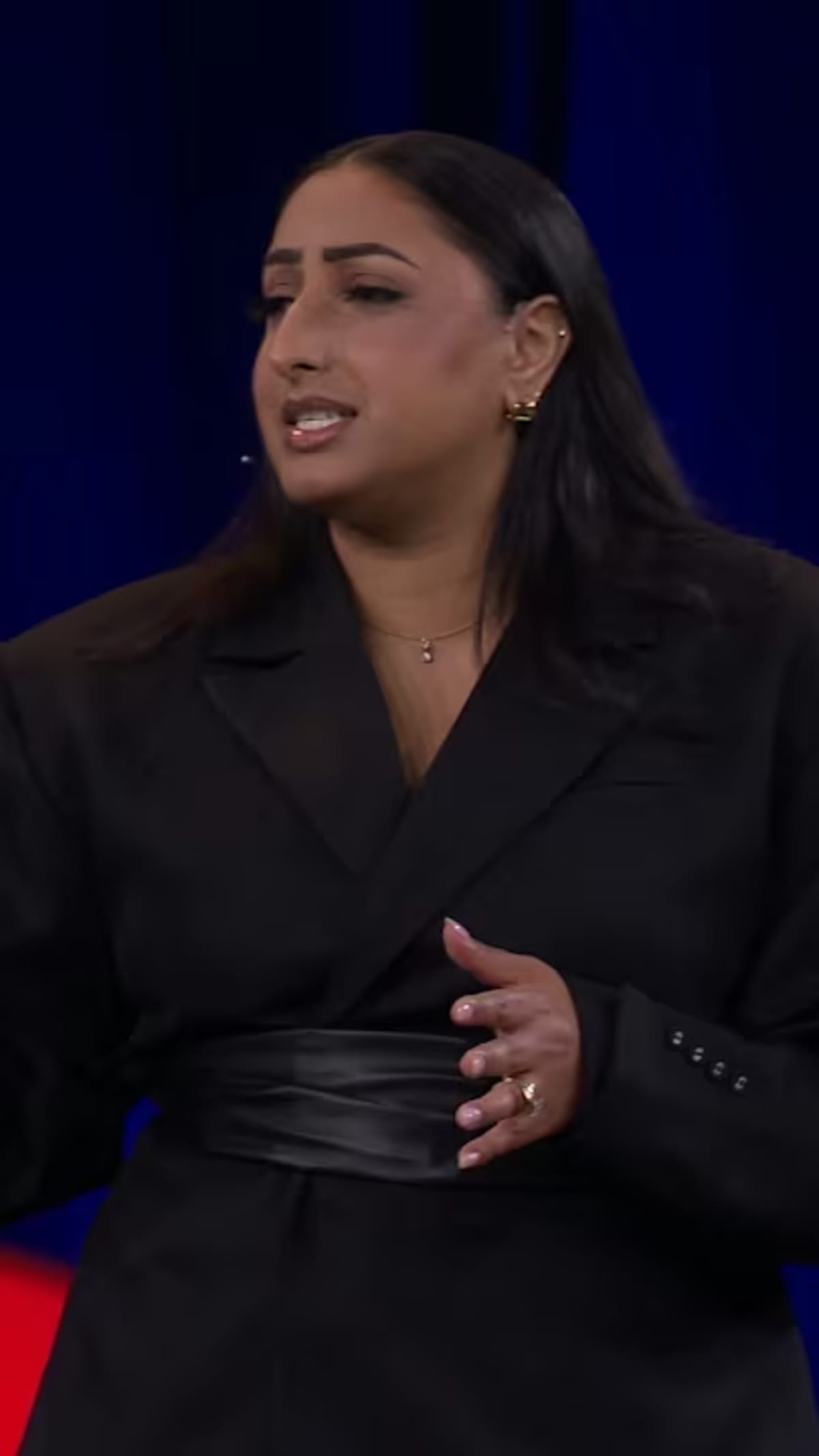 Professional woman speaking at TED Talk about preventing workplace burnout and sustainable ambition