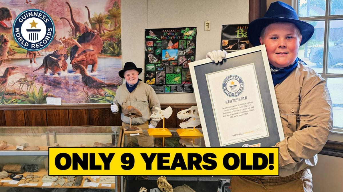 Young boy Anderson Taylor standing proudly beside display cases in his natural history museum