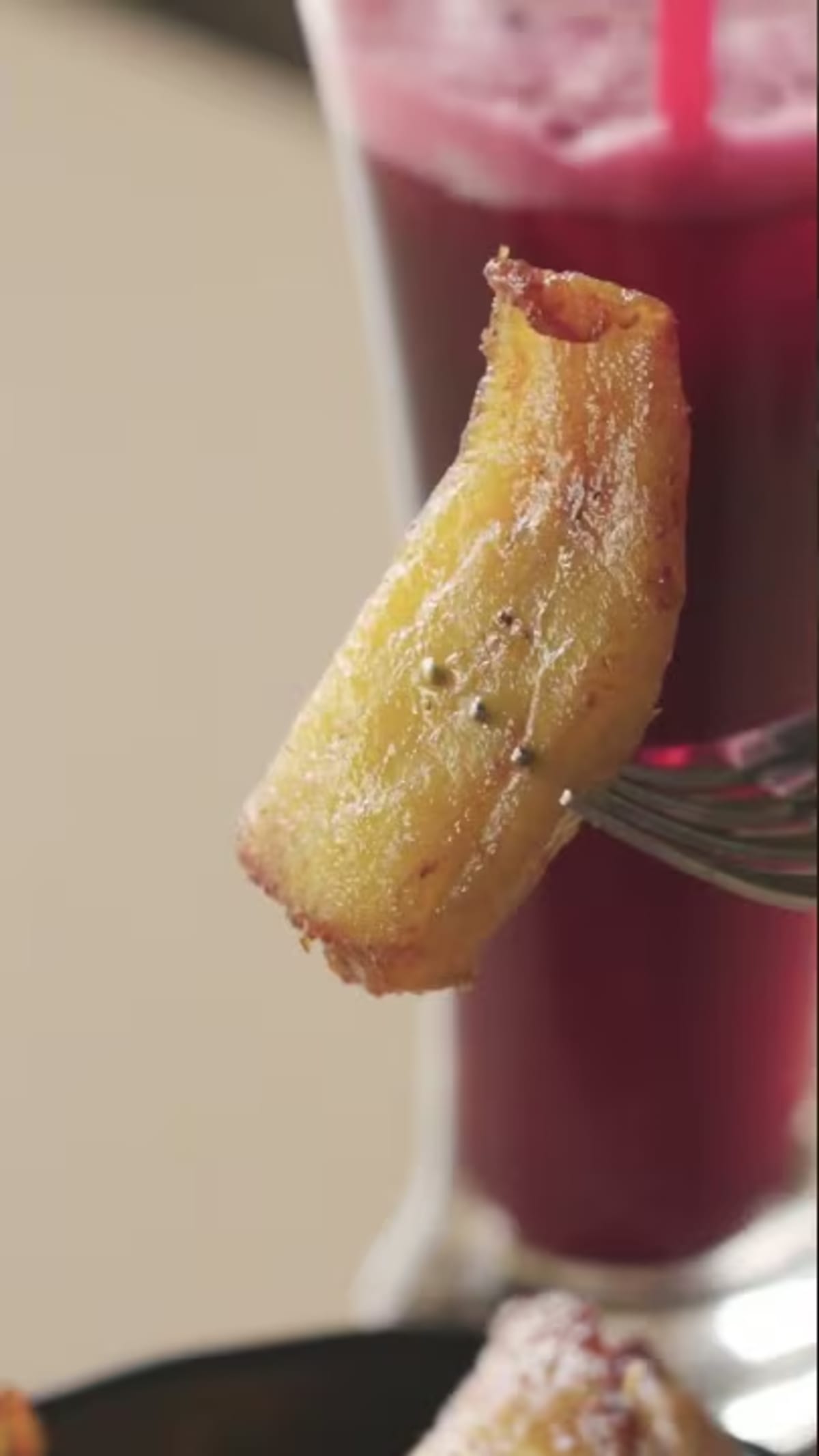 Steaming bowl of Nigerian pepper soup with fried plantains and samosas on table