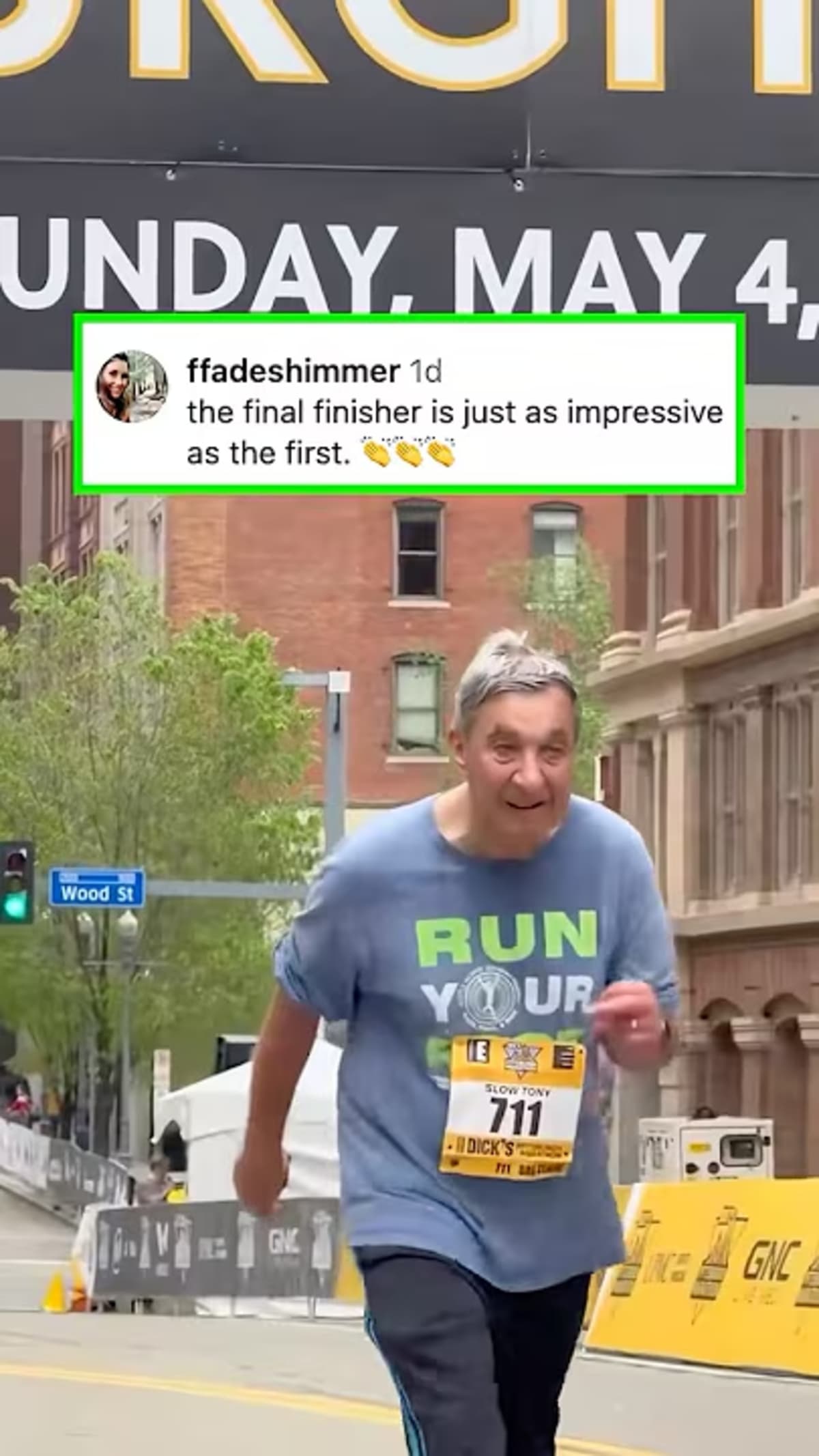 ** Final marathon runner crossing finish line while crowd cheers and celebrates their achievement