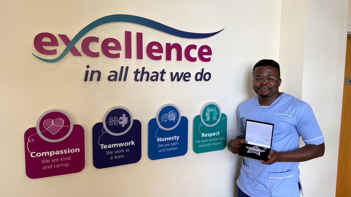 Nurse Emmanuel Ndubuisi standing in hospital scrubs after receiving national bravery award