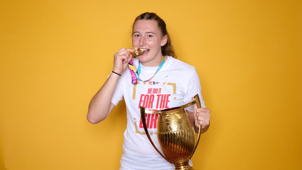 Emma Sing holding the Women's Rugby World Cup trophy in England jersey