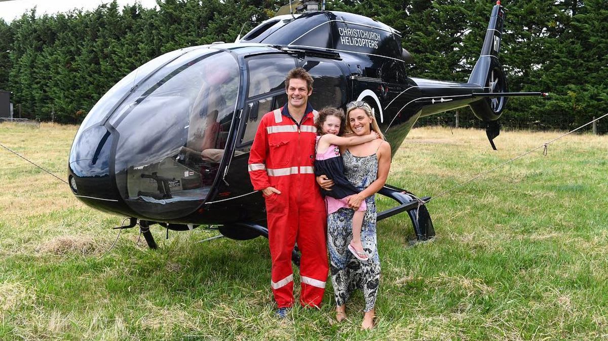 Former All Blacks captain Richie McCaw standing in front of helicopter in pilot uniform