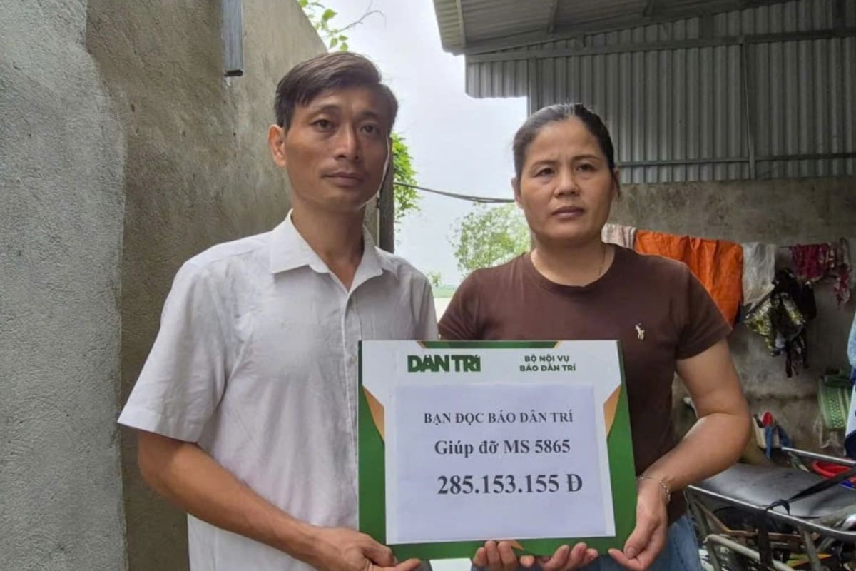 Vietnamese mother Nguyen Thi Lien receives symbolic donation check from newspaper representatives and local officials