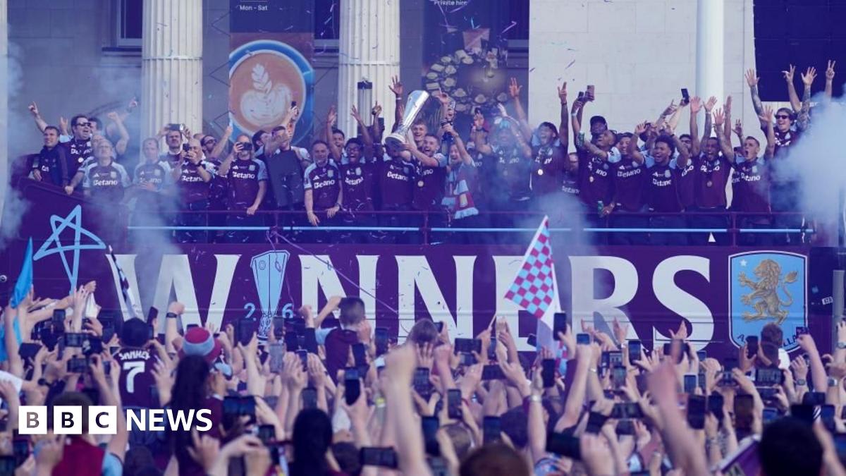 ** Aston Villa players lift Europa League trophy on double-decker bus surrounded by thousands of celebrating fans