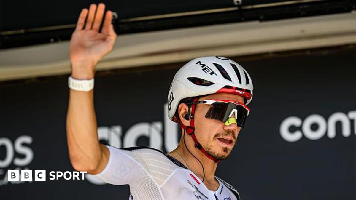 Cyclist Rui Oliveira celebrating victory with Porto football jersey draped over shoulders