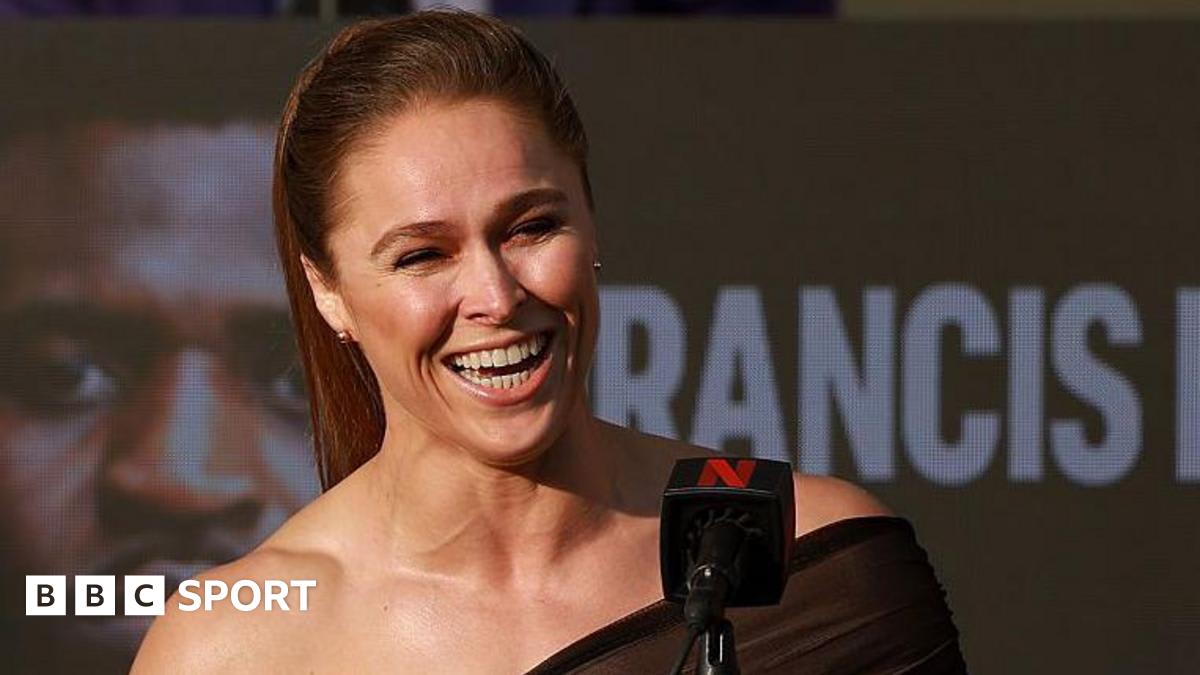 Ronda Rousey in fighting stance wearing athletic gear, determined expression on face