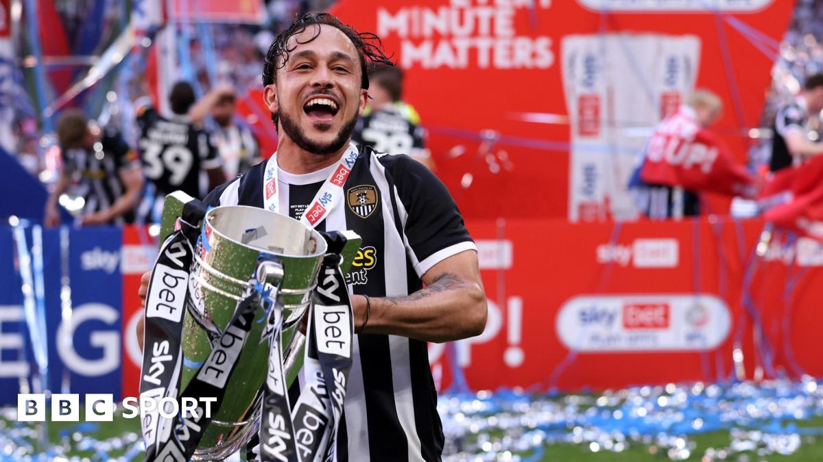 Jodi Jones celebrating on the Wembley pitch in Notts County kit holding championship trophy