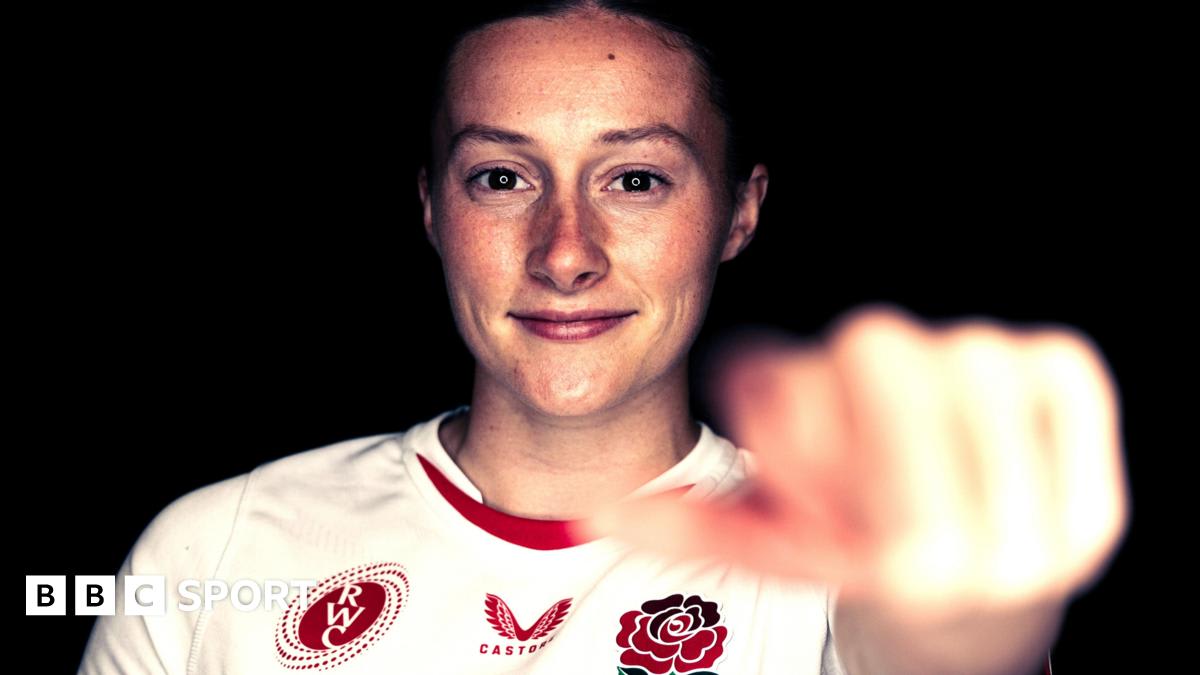 Lucy Packer in England rugby uniform preparing to pass the ball during a match