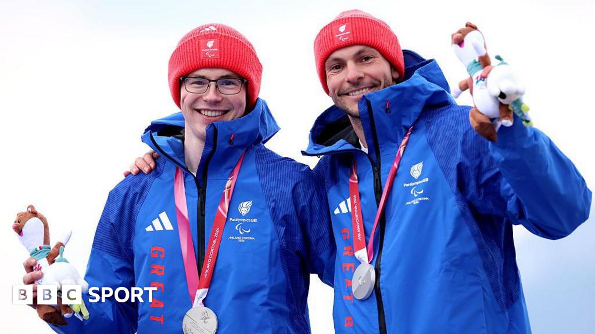 Neil Simpson and guide Rob Poth celebrating on podium with silver medals at Winter Paralympics