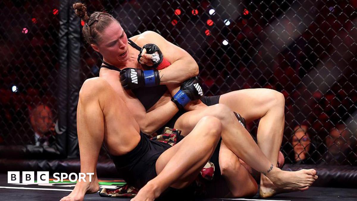 Ronda Rousey applying armbar submission technique to Gina Carano in MMA octagon