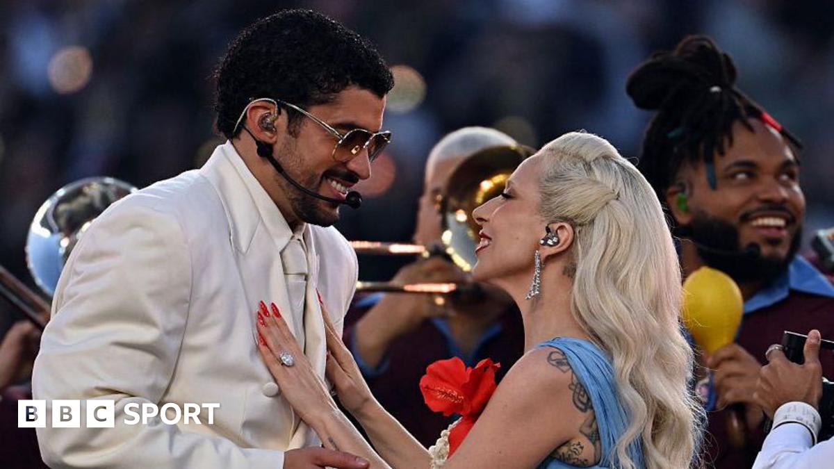 NFL half-time show performer on brightly lit stage with massive crowd watching