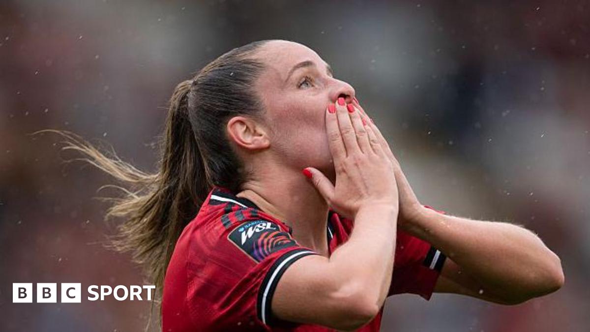 England midfielder Ella Toone celebrating a goal on the football pitch pointing skyward