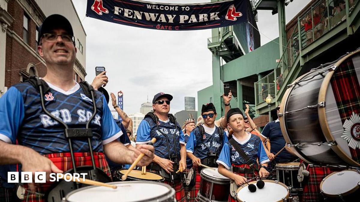 Scottish fans in kilts and tartan celebrating at historic Fenway Park baseball stadium