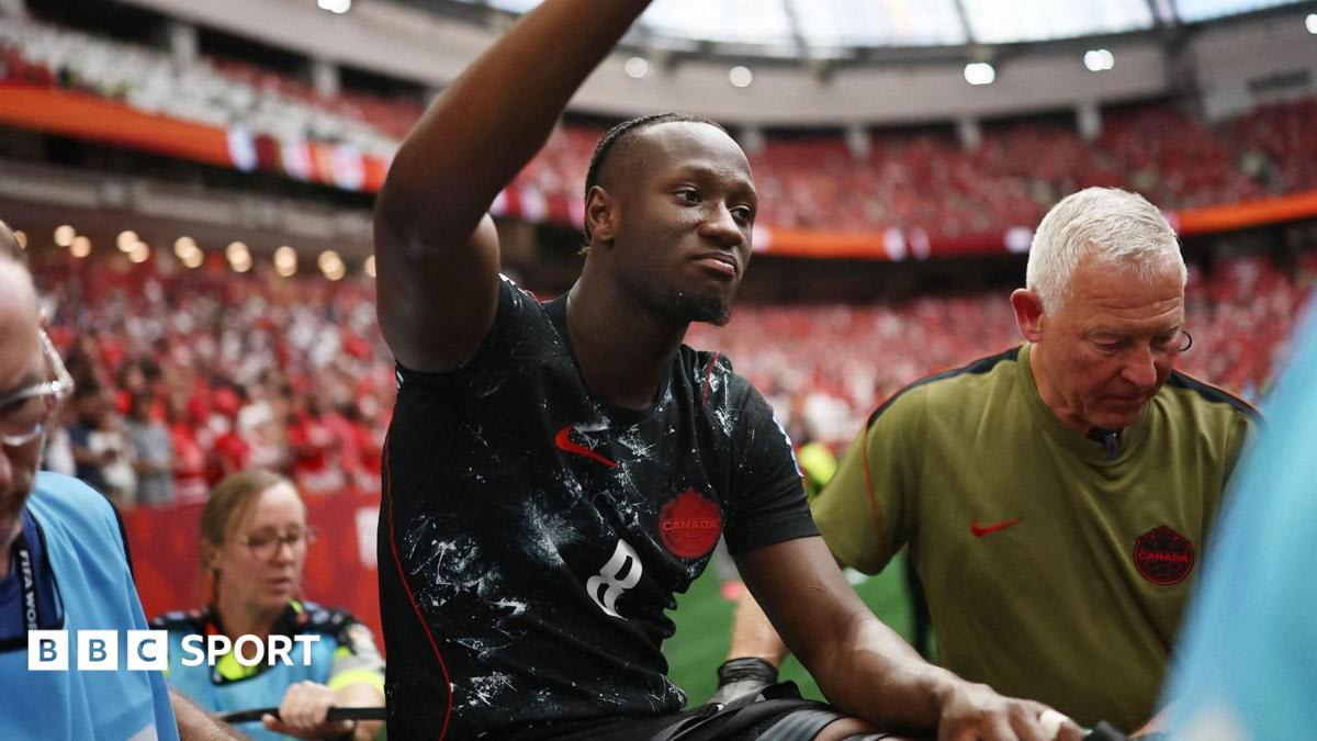 Canada midfielder Ismael Kone waving to supportive crowd while on stretcher after leg injury